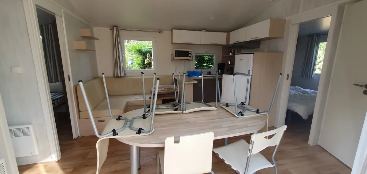 Séjour lumineux avec coin cuisine équipée et espace repas dans l'hébergement familial
